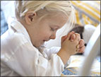 daily Devotion picture of little blonde child praying with eyes closed and hands clasped
