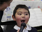 Kindergarteners and staff perform special songs in gratitude for the gift of a new bus.