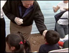 Pat Robertson distributes pills to rid children in Peru of intestinal parasites.