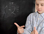 boy child at chalkboard solving math equation