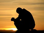 silhouette of man praying