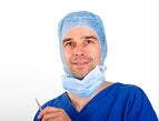 surgeon holding scalpel wearing blue scrubs