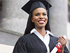 female graduate in cap and gown accepting diploma